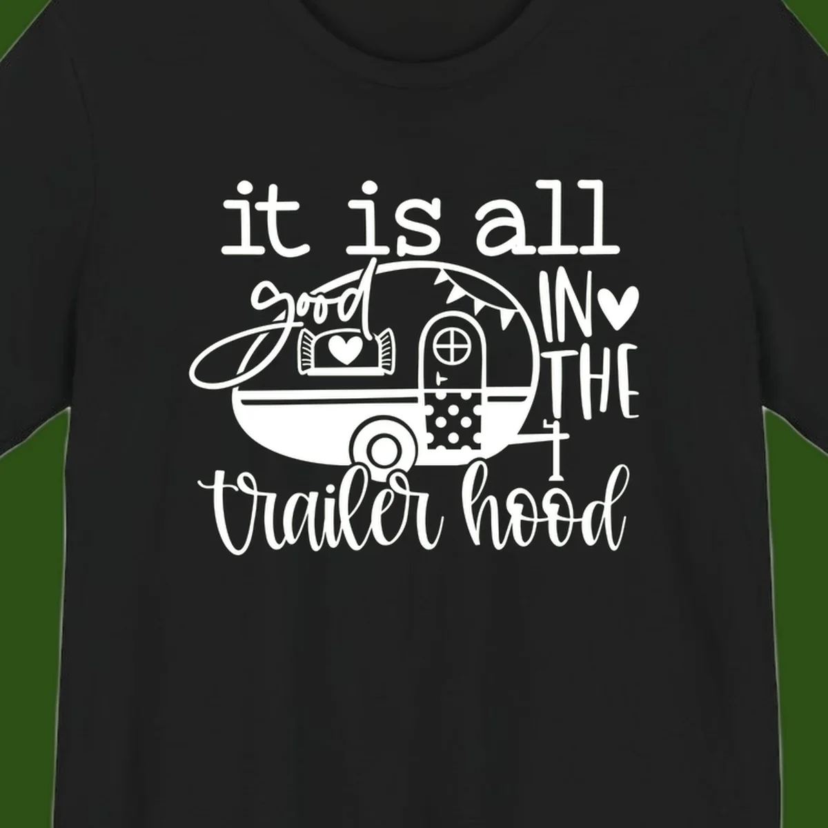 Vintage trailer illustration with decorative hearts and bunting, text reading 'it is all good in the trailer hood' in retro style