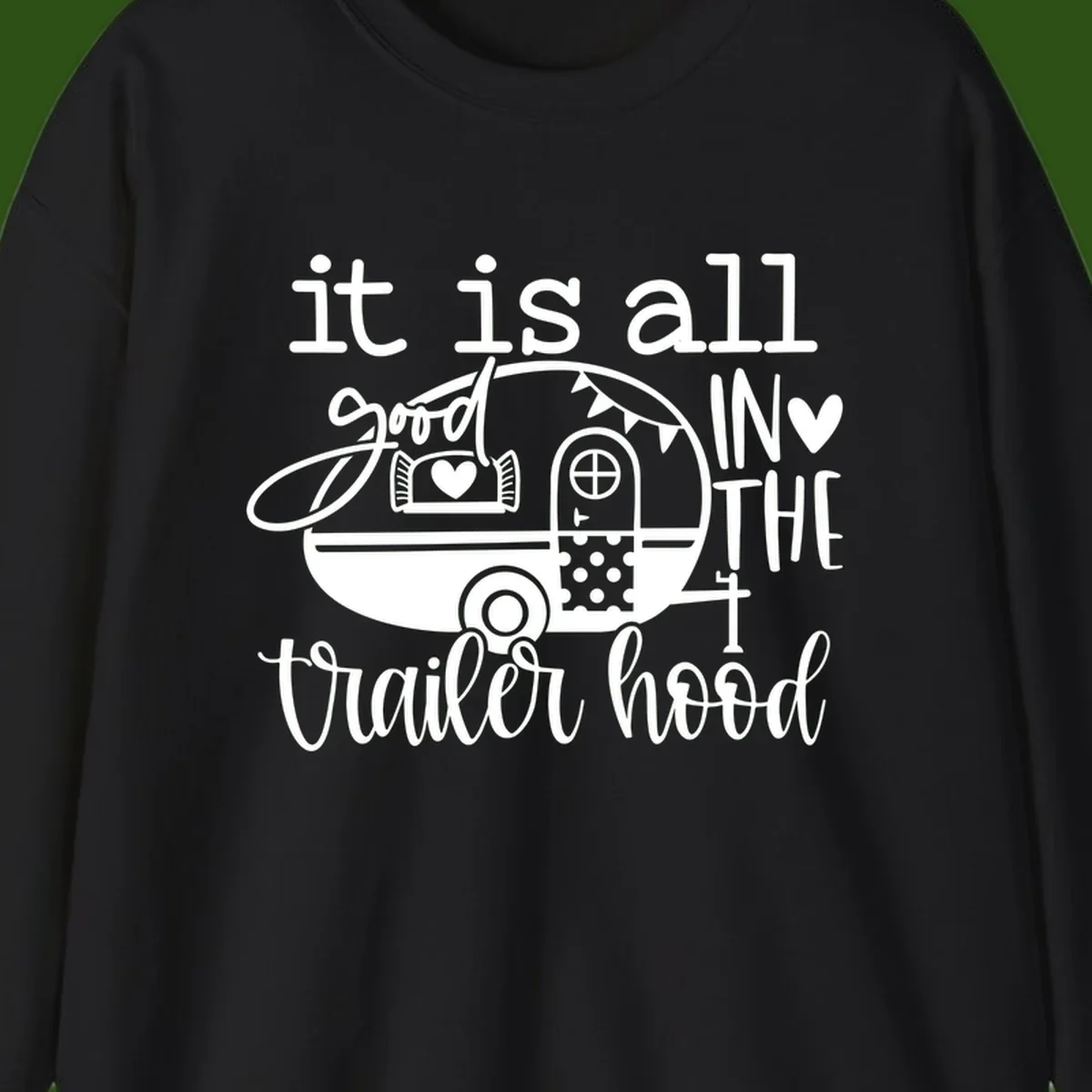 Vintage trailer illustration with decorative hearts and bunting, text reading 'it is all good in the trailer hood' in retro style