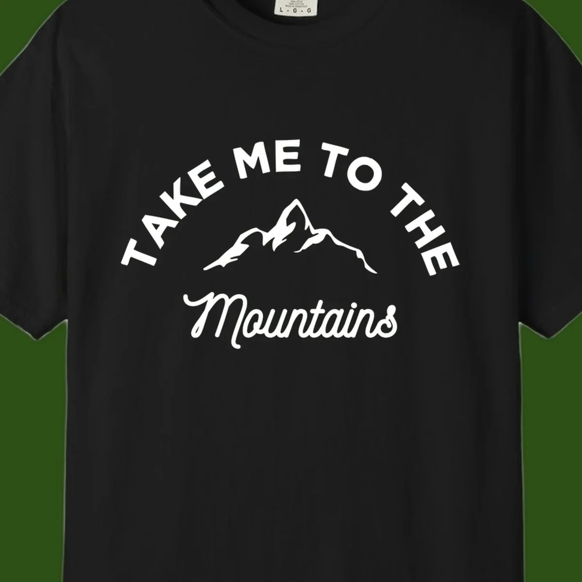White mountain silhouette with curved text reading 'Take Me To The Mountains' on gray background