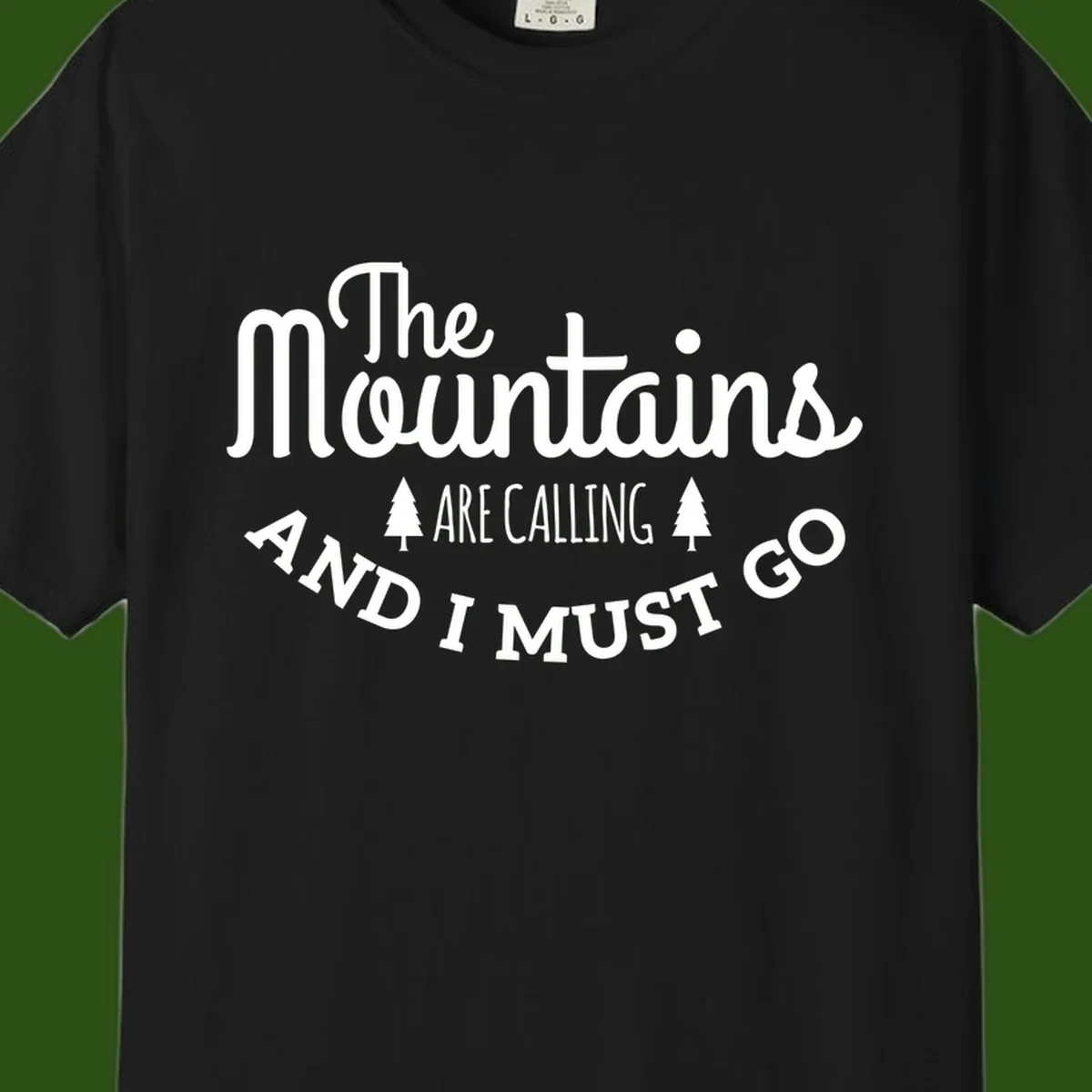 White text reading "The Mountains Are Calling And I Must Go" with pine trees on gray background