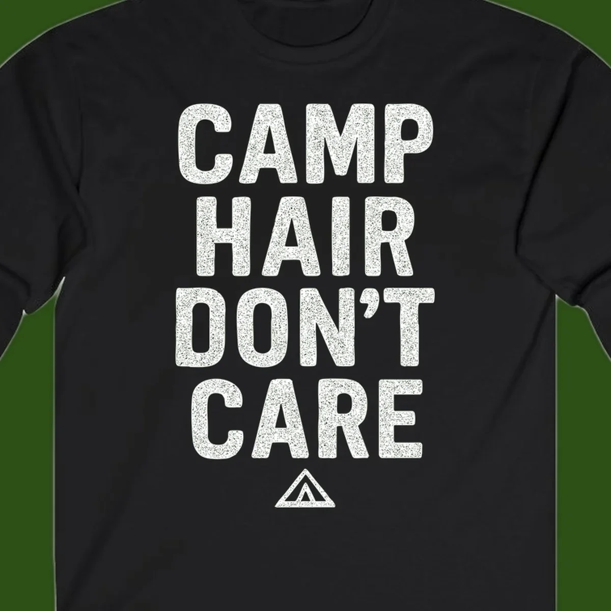 White speckled text reading 'Camp Hair Don't Care' with triangle symbol on gray background