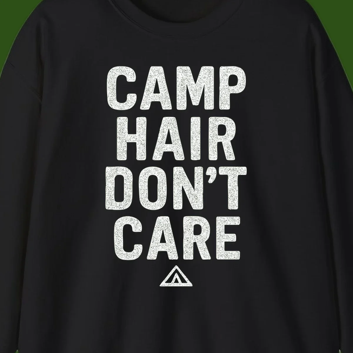 White speckled text reading 'Camp Hair Don't Care' with triangle symbol on gray background