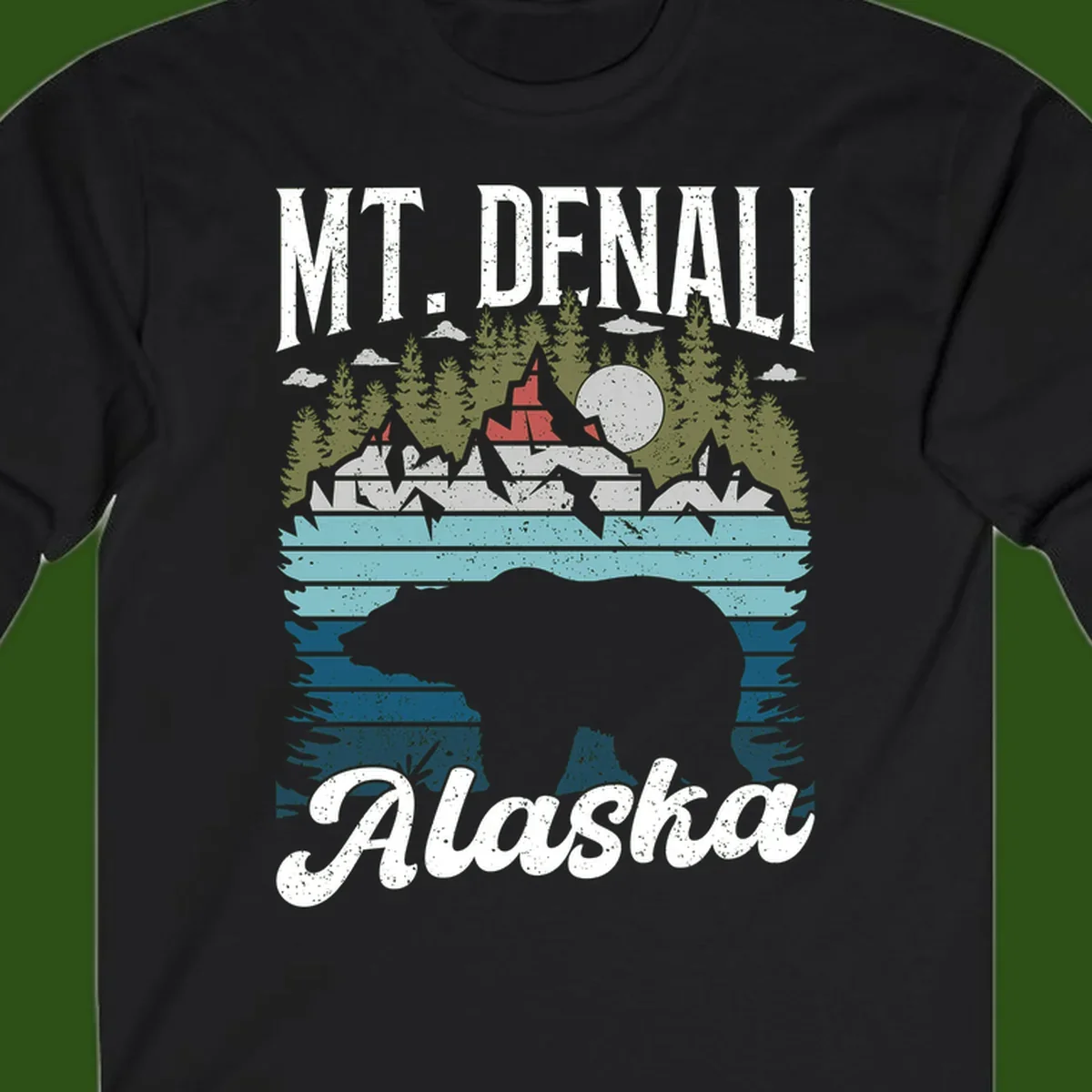 Denali bear Alaska design: layered illustration with silhouetted bear emerging from water, mountain peaks, fortress, forest, and full moon.