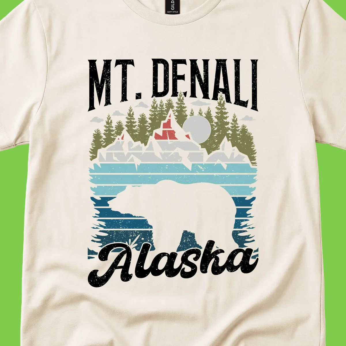 Denali bear Alaska design: layered illustration with silhouetted bear emerging from water, mountain peaks, fortress, forest, and full moon.