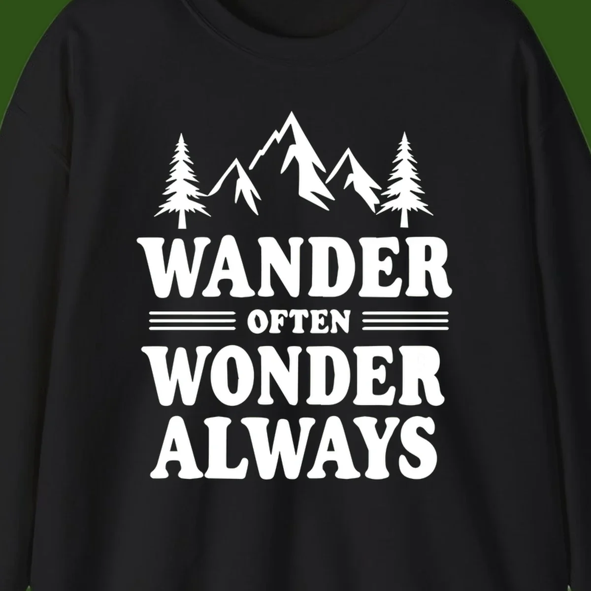 White mountain and evergreen tree illustration with 'Wander Often Wonder Always' text on gray background