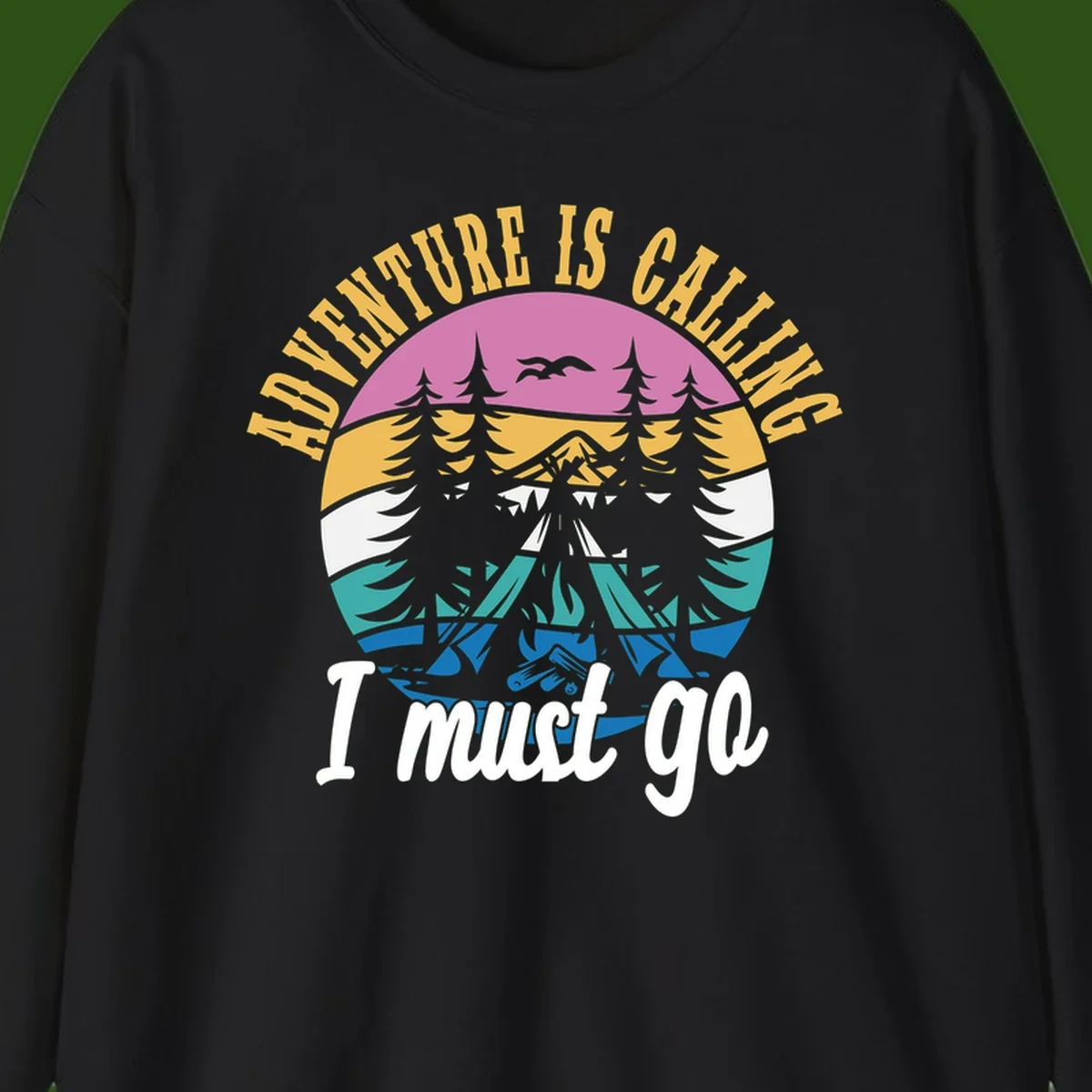 Circular badge with mountain landscape, evergreen trees, and flying birds in pink, gold, white, teal and blue with text 'Adventure Is Calling I Must Go'