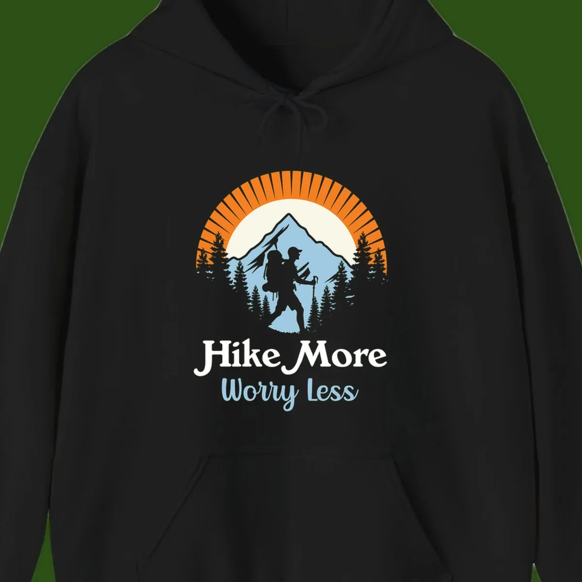 Hike more worry less badge design with silhouetted hiker, mountain peak, and evergreen forest in circular composition.