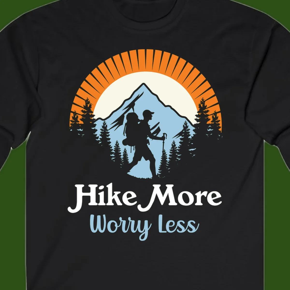 Hike more worry less badge design with silhouetted hiker, mountain peak, and evergreen forest in circular composition.