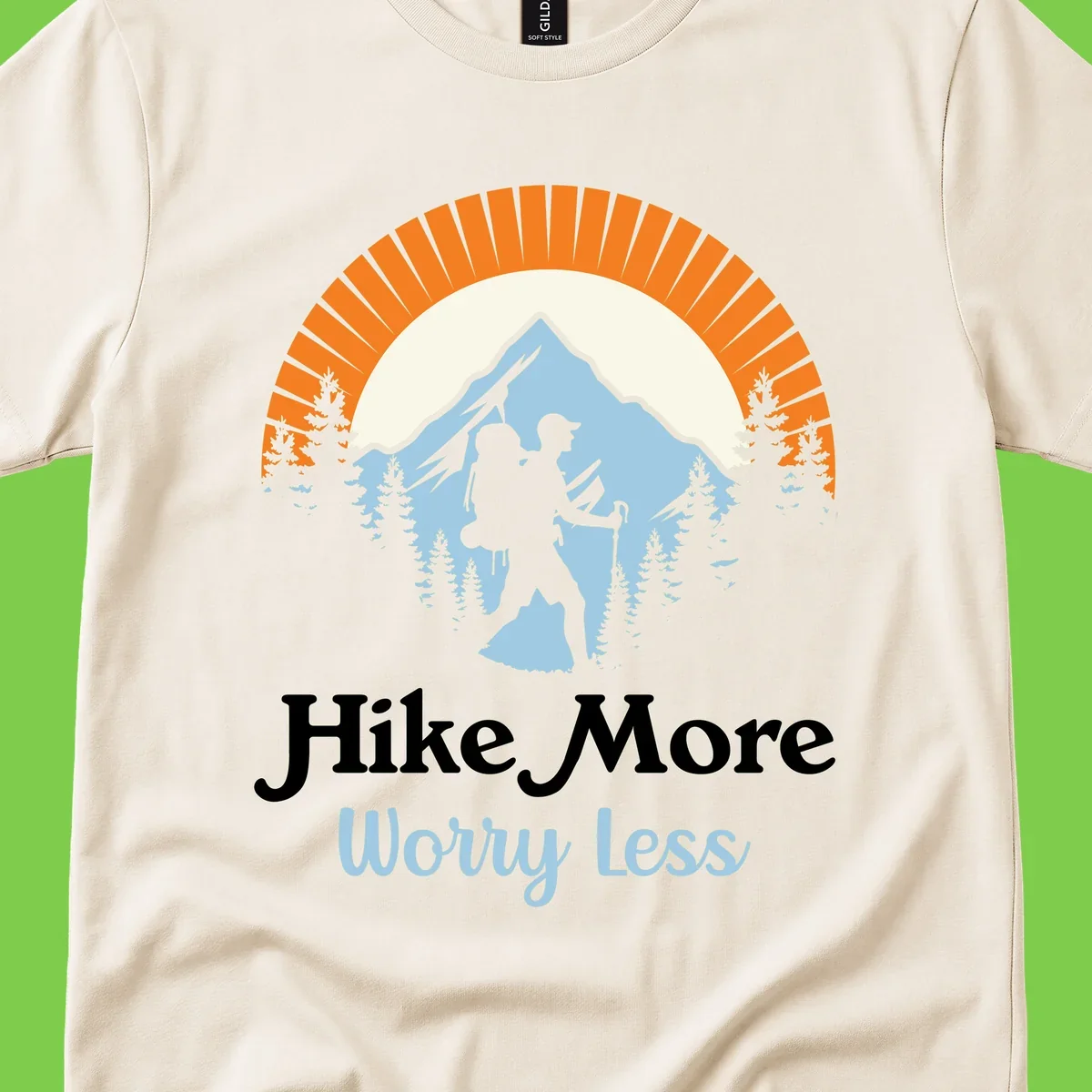 Hike more worry less badge design with silhouetted hiker, mountain peak, and evergreen forest in circular composition.