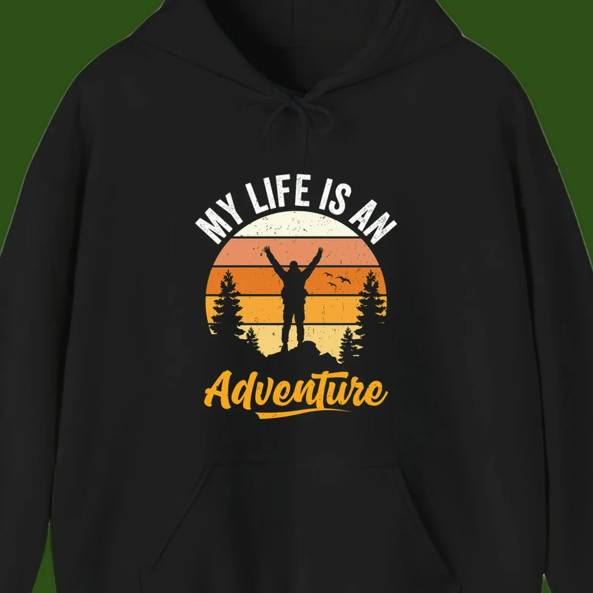 Retro sunset illustration with silhouette of person celebrating arms raised, evergreen trees and mountains, text 'My Life Is An Adventure'