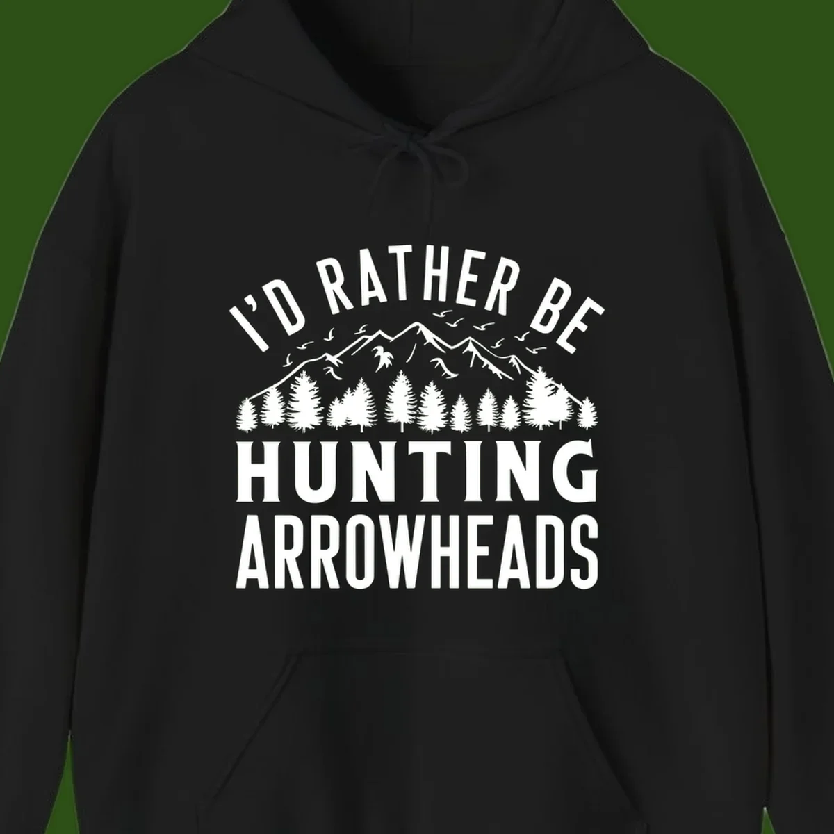 Mountain landscape with evergreen trees and birds, white text reading 'I'd Rather Be Hunting Arrowheads' on gray background