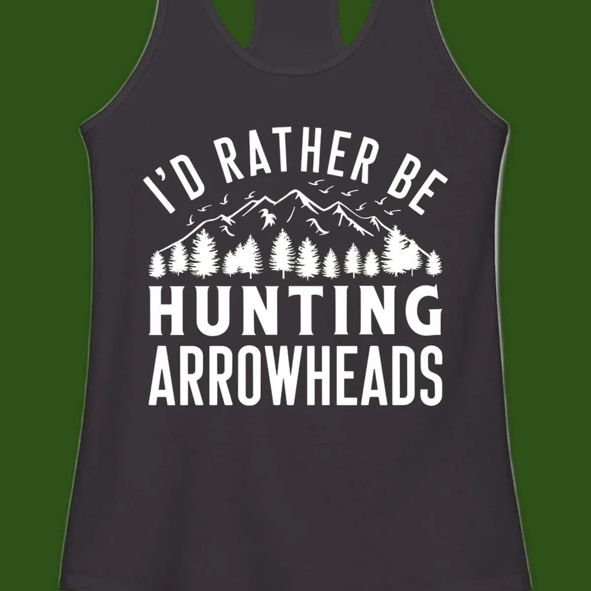 Mountain landscape with evergreen trees and birds, white text reading 'I'd Rather Be Hunting Arrowheads' on gray background
