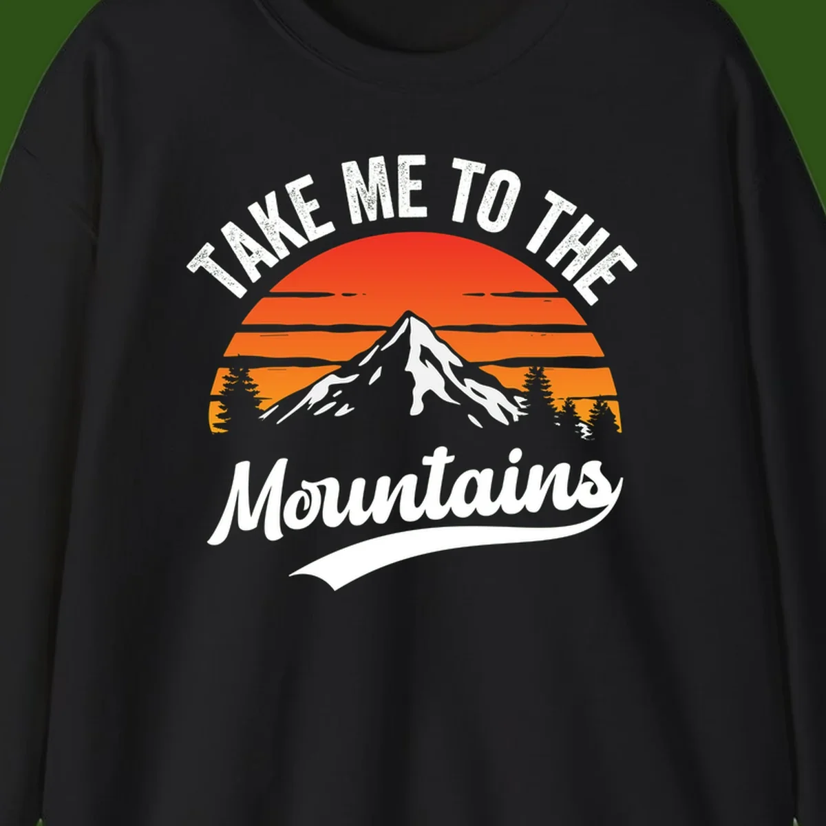 Vintage-style illustration of snow-capped mountain with sunset stripes and evergreen trees, text reading 'Take Me To The Mountains'