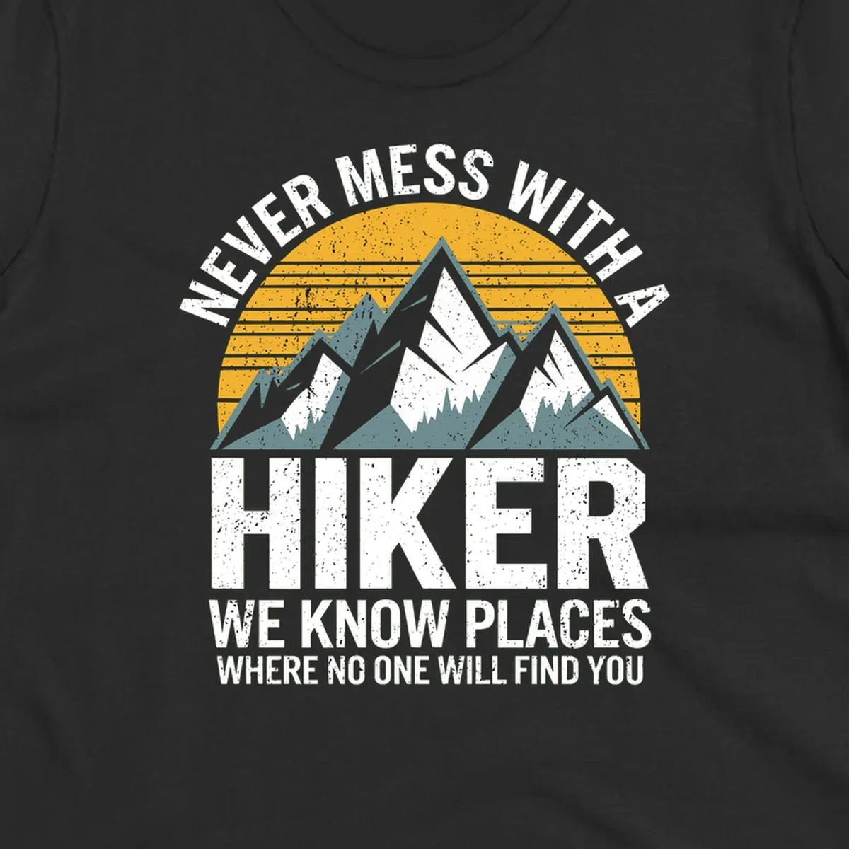 Vintage-style design with snow-capped mountains and forest silhouette against striped sunset, text reads 'Never Mess With A Hiker We Know Places Where No One Will Find You'