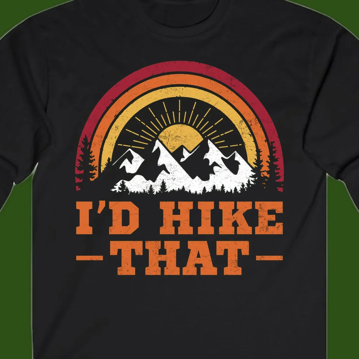 Vintage badge design with snow-capped mountains, evergreen trees, golden sun rays, and text reading 'I'd Hike That' in retro style