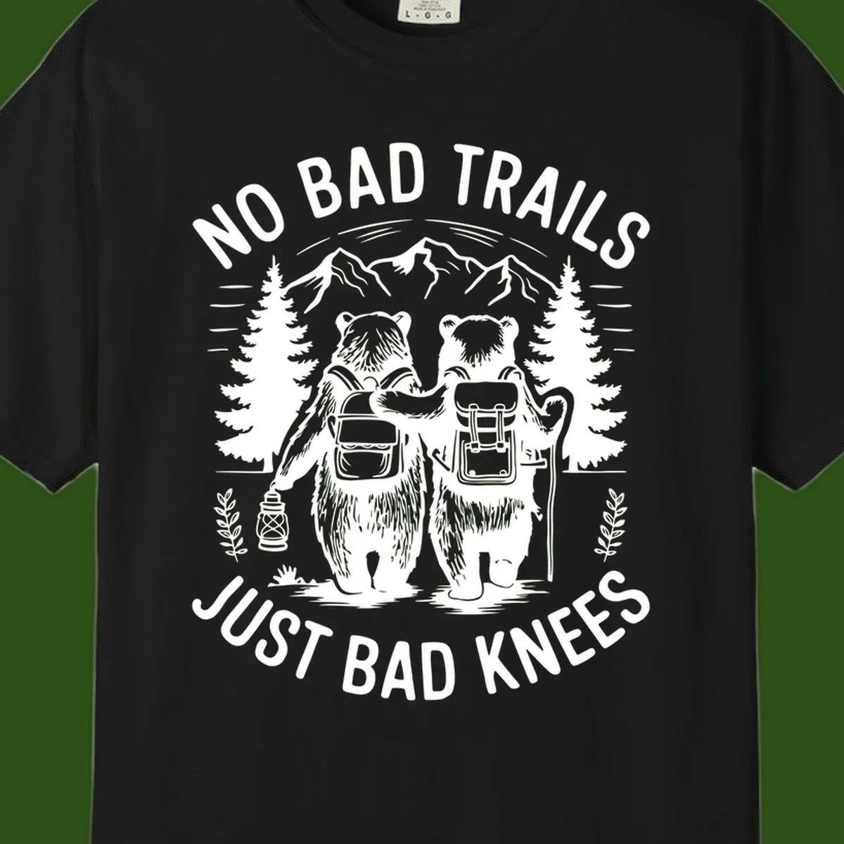 Two cartoon bears with backpacks hiking in mountains with text 'No Bad Trails Just Bad Knees' - humorous outdoor camping design