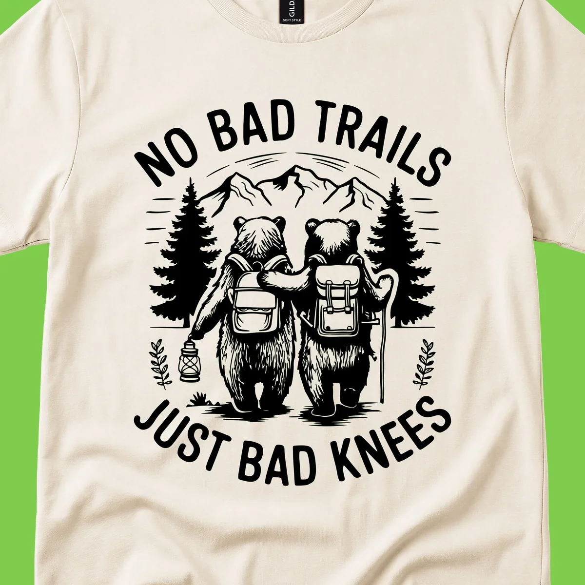 Two cartoon bears with backpacks hiking in mountains with text 'No Bad Trails Just Bad Knees' - humorous outdoor camping design