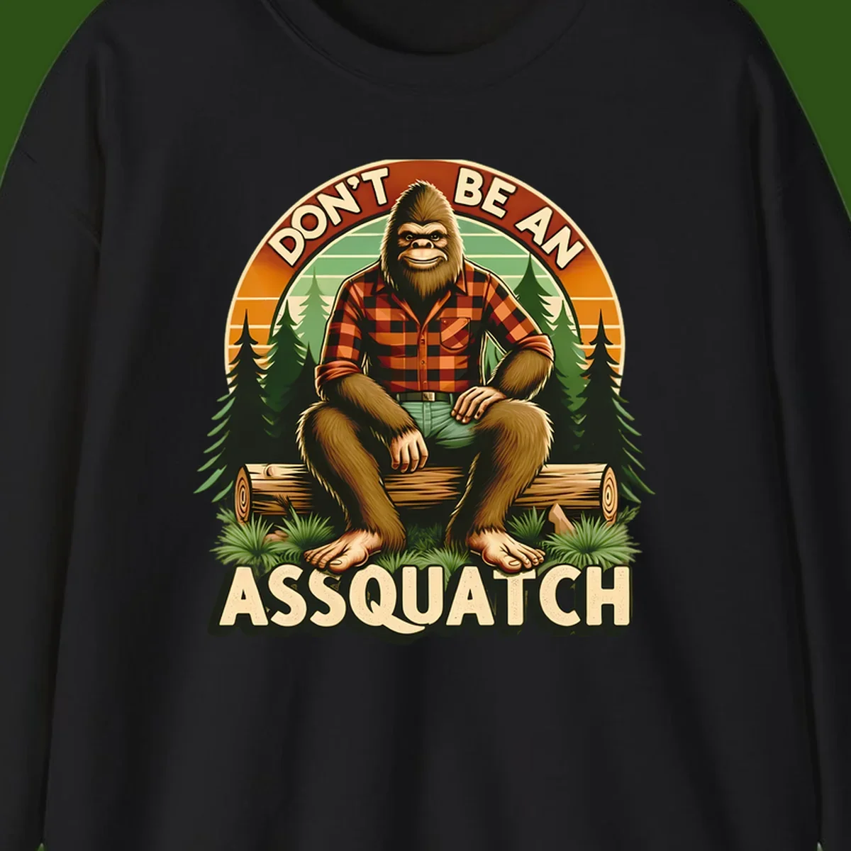 Vintage badge design with friendly Bigfoot in plaid shirt sitting on a log with forest trees, text reads 'Don't Be An Assquatch'