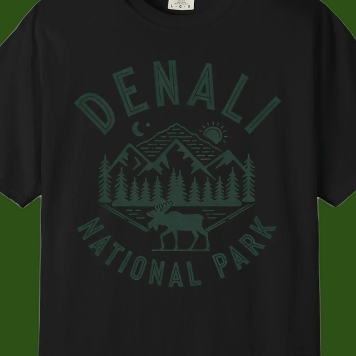 Denial National Park badge design with moose walking through forest, mountains, sun and moon with crossed fishing rods