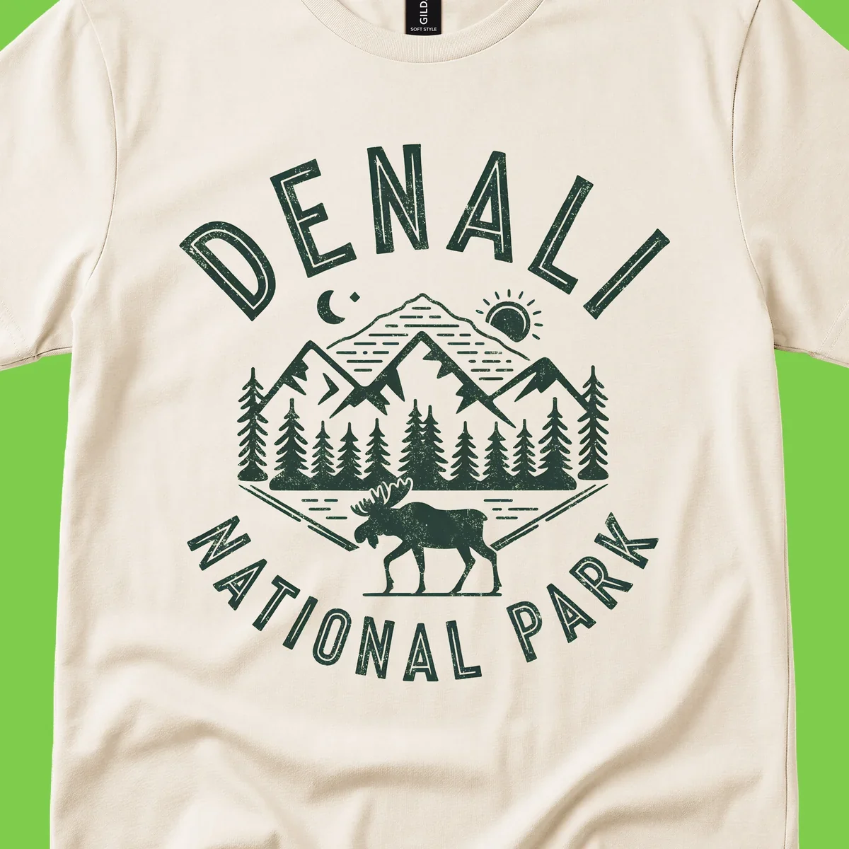 Denial National Park badge design with moose walking through forest, mountains, sun and moon with crossed fishing rods