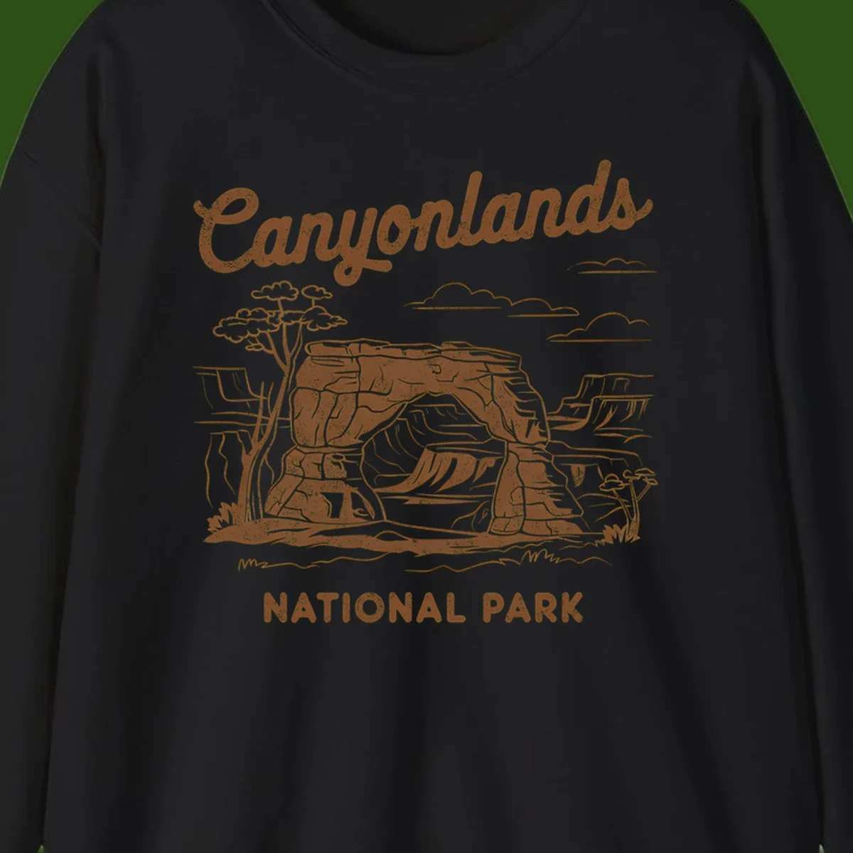 Vintage illustration of Canyonlands National Park featuring layered red rock canyon formations, desert acacia tree, and clouds in rust orange line art.