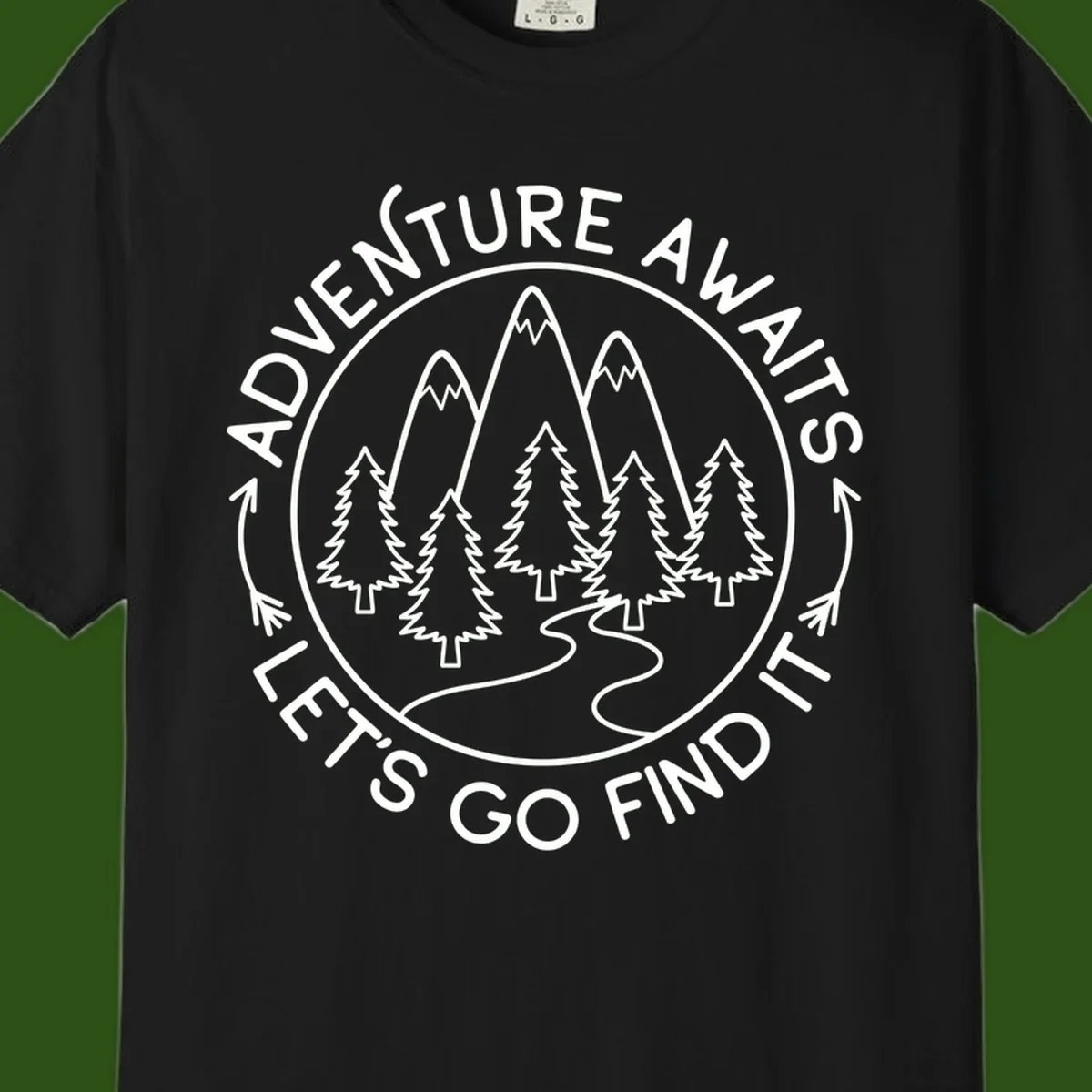 Circular badge with forest scene of evergreen trees and mountains, text reads 'Adventure Awaits Let's Go Find It'