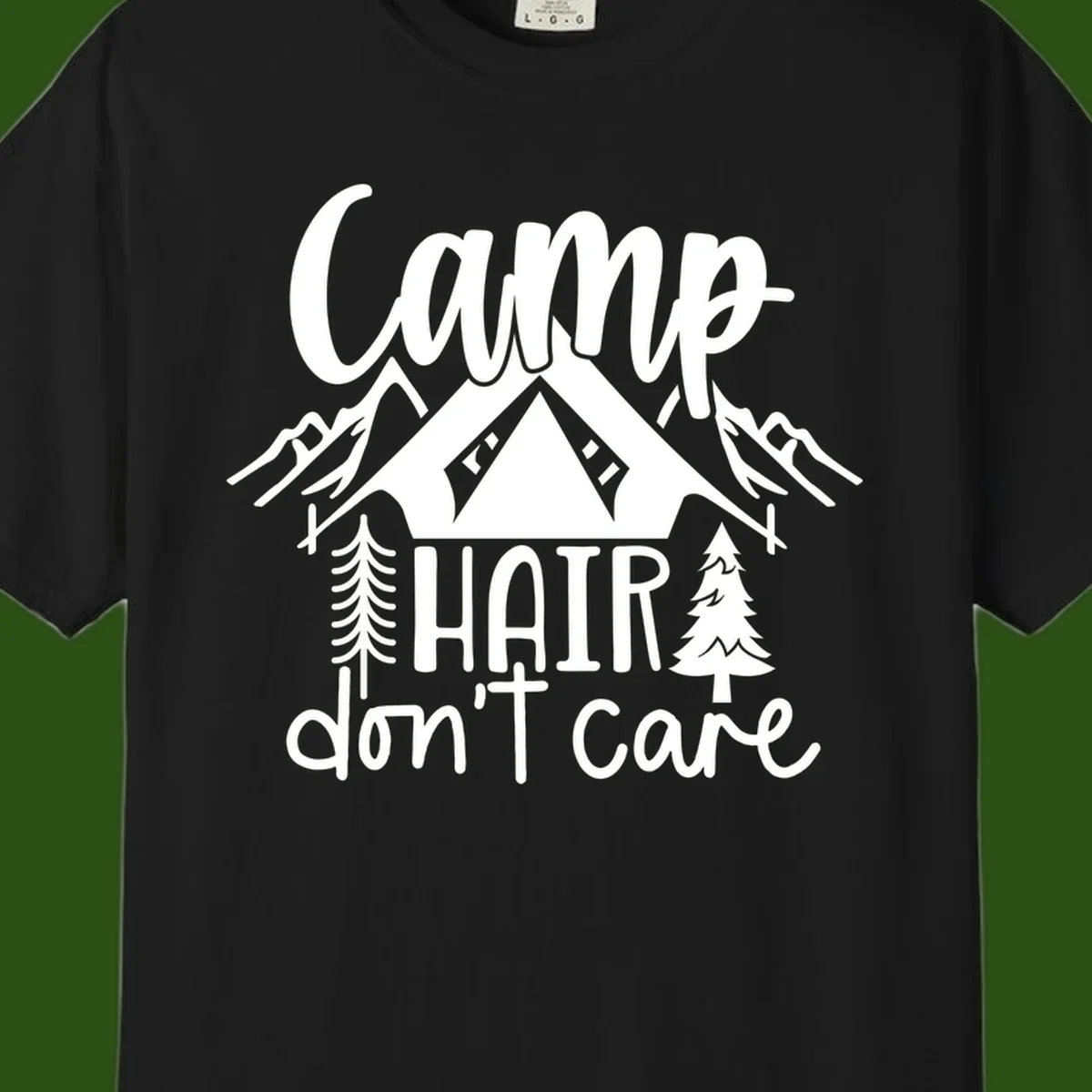 Camp hair don't care design with tent, mountains, pine trees, and campfire illustration with cursive text