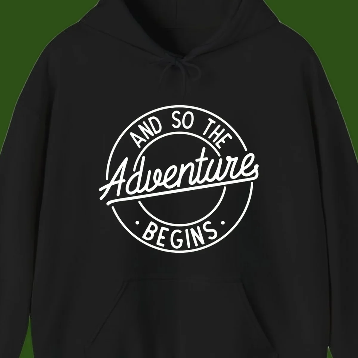 Vintage circular badge design with white text reading 'And So The Adventure Begins' on gray background