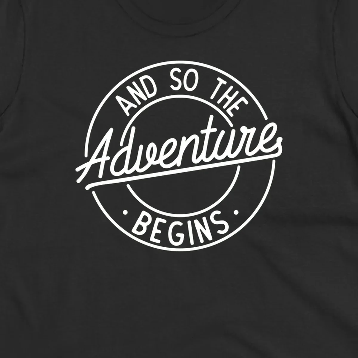 Vintage circular badge design with white text reading 'And So The Adventure Begins' on gray background