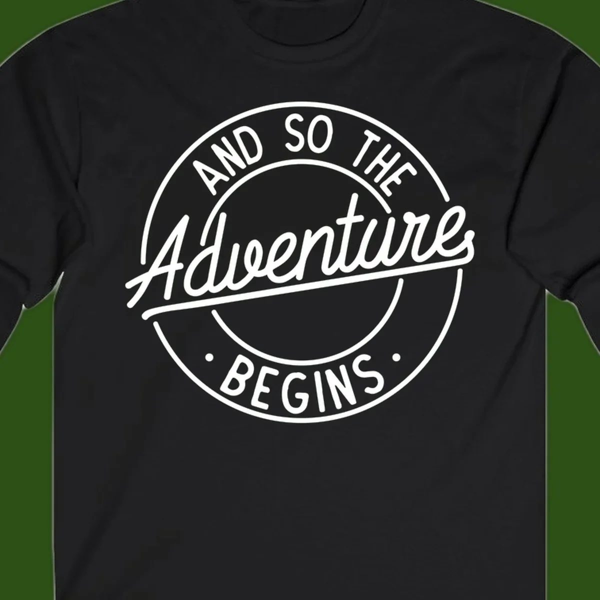 Vintage circular badge design with white text reading 'And So The Adventure Begins' on gray background