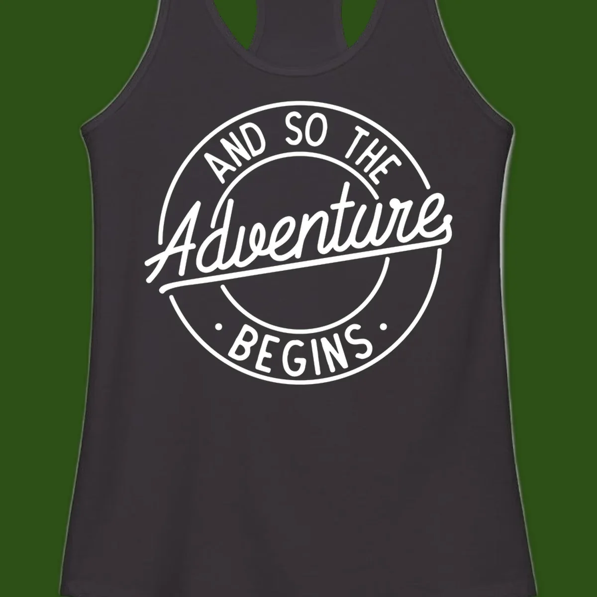 Vintage circular badge design with white text reading 'And So The Adventure Begins' on gray background