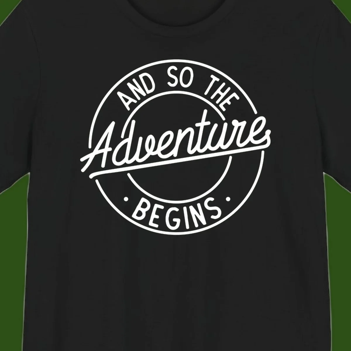 Vintage circular badge design with white text reading 'And So The Adventure Begins' on gray background