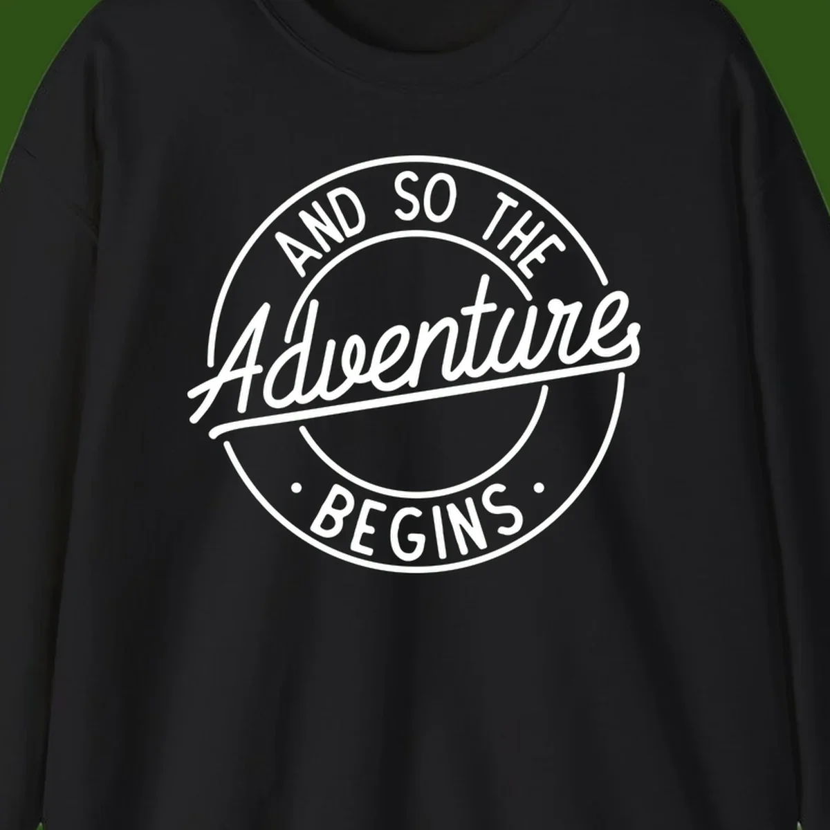 Vintage circular badge design with white text reading 'And So The Adventure Begins' on gray background