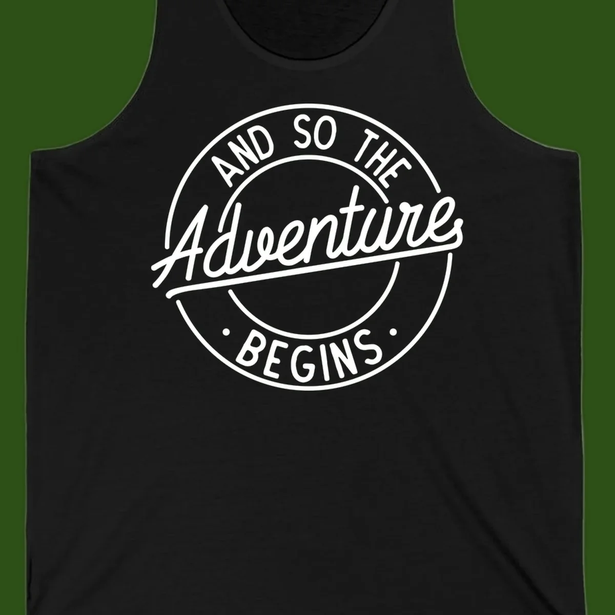 Vintage circular badge design with white text reading 'And So The Adventure Begins' on gray background
