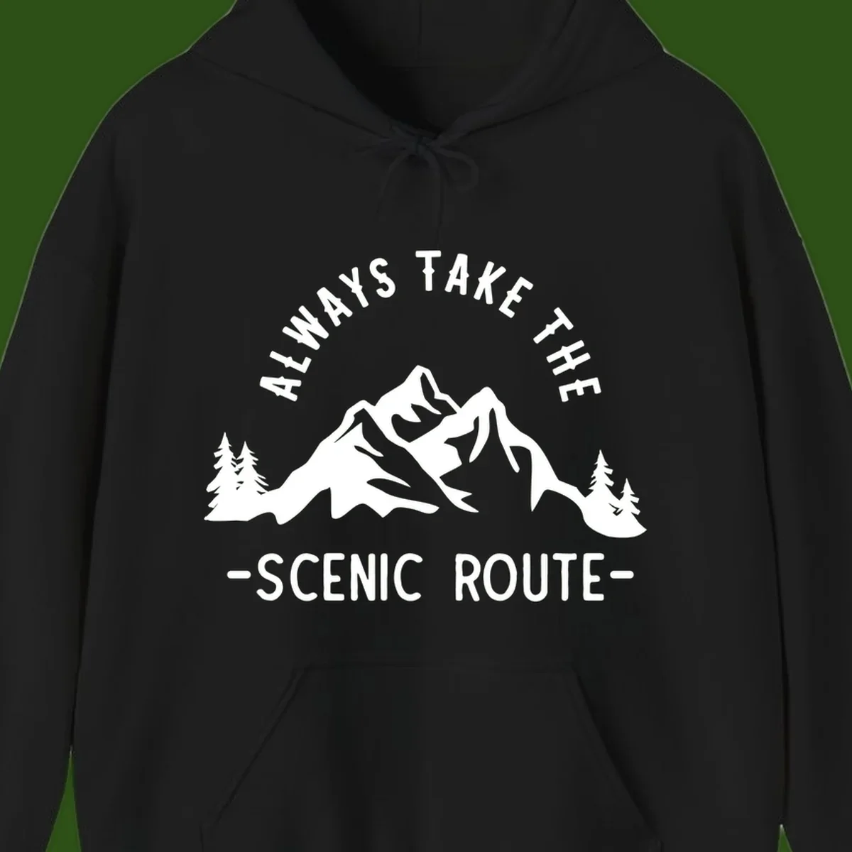 Mountain landscape with evergreen trees and text reading 'Always Take The Scenic Route' in bold lettering