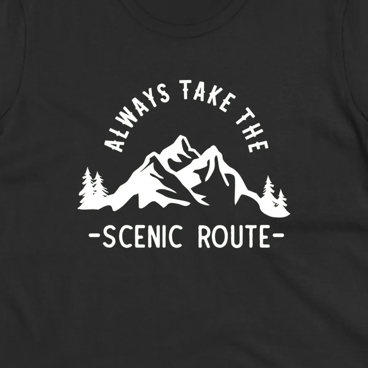 Mountain landscape with evergreen trees and text reading 'Always Take The Scenic Route' in bold lettering