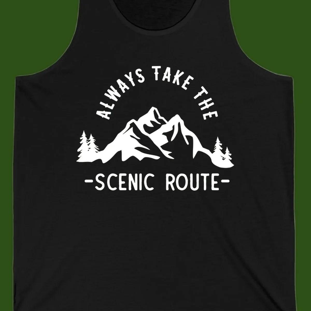 Mountain landscape with evergreen trees and text reading 'Always Take The Scenic Route' in bold lettering