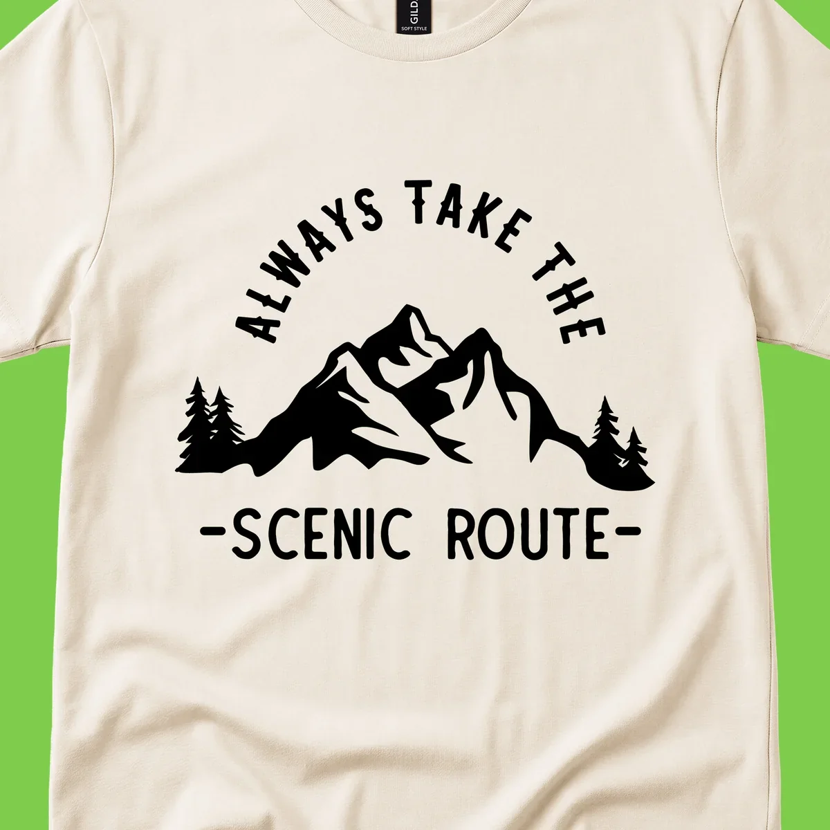 Mountain landscape with evergreen trees and text reading 'Always Take The Scenic Route' in bold lettering