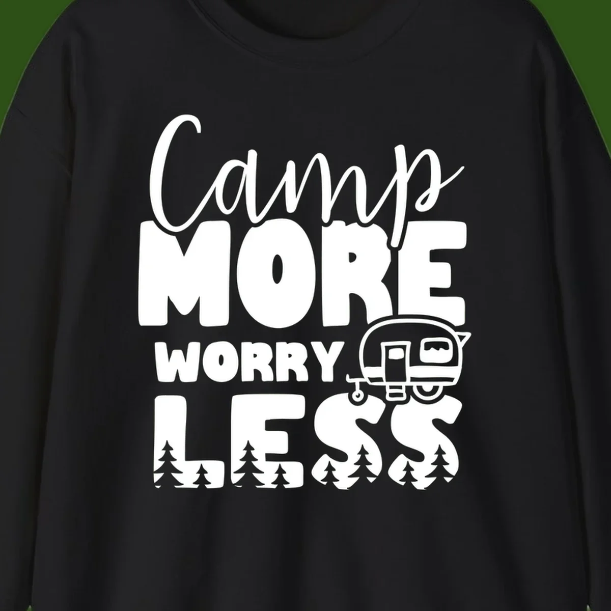 Camp More Worry Less design with flowing script text, camping trailer, and pine trees on gray background