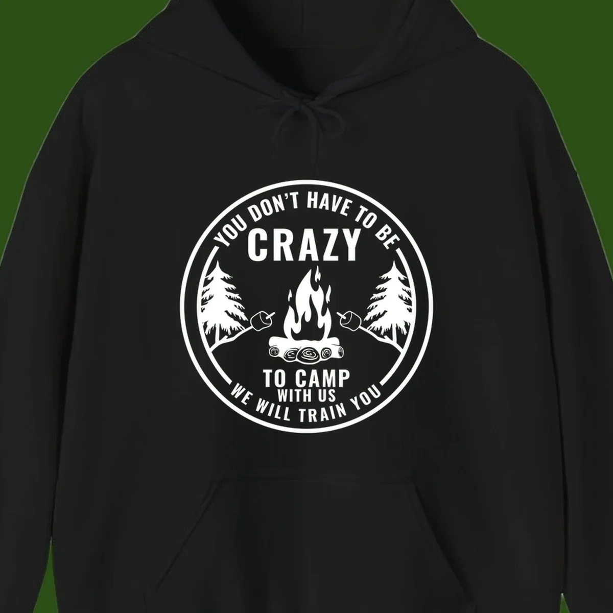Circular badge design with campfire, pine trees, and marshmallows on sticks with humorous camping text about training crazy campers