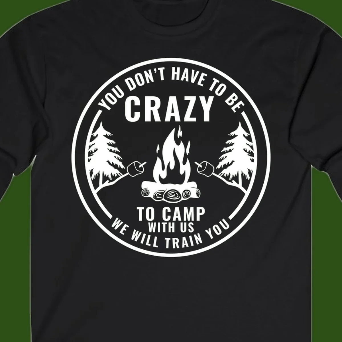 Circular badge design with campfire, pine trees, and marshmallows on sticks with humorous camping text about training crazy campers