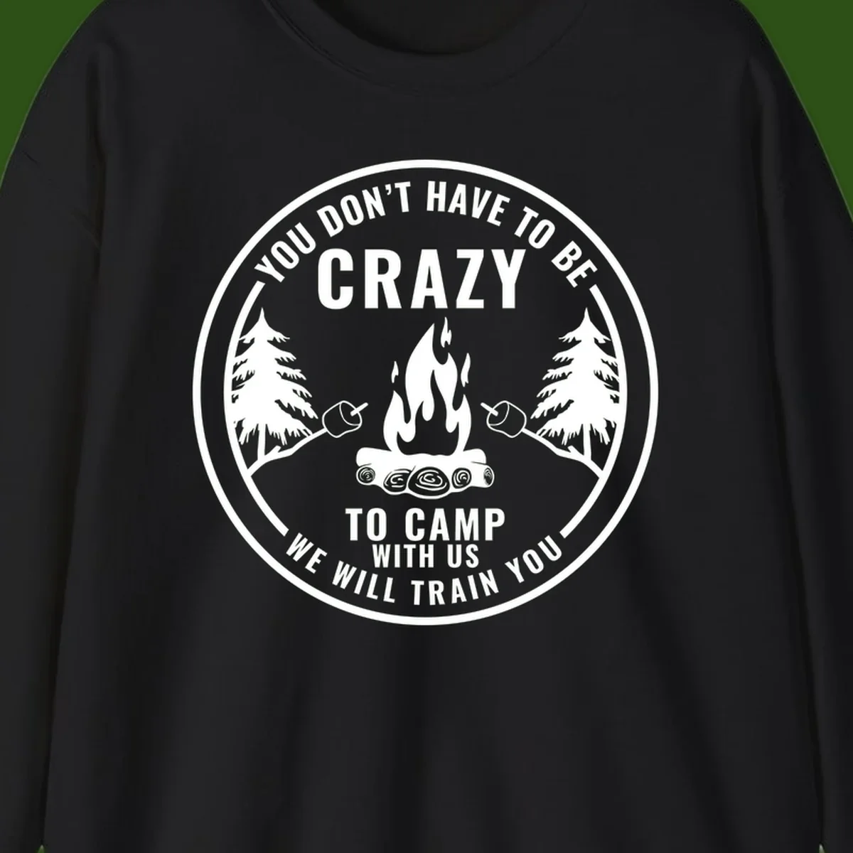 Circular badge design with campfire, pine trees, and marshmallows on sticks with humorous camping text about training crazy campers