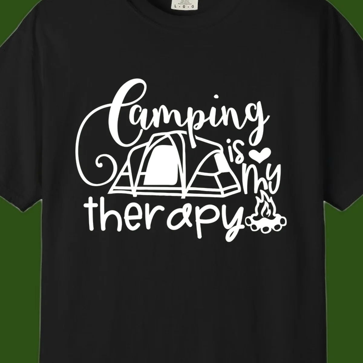 White lettered design reading 'Camping is Therapy' with heart symbol, tent, and campfire illustration on gray background