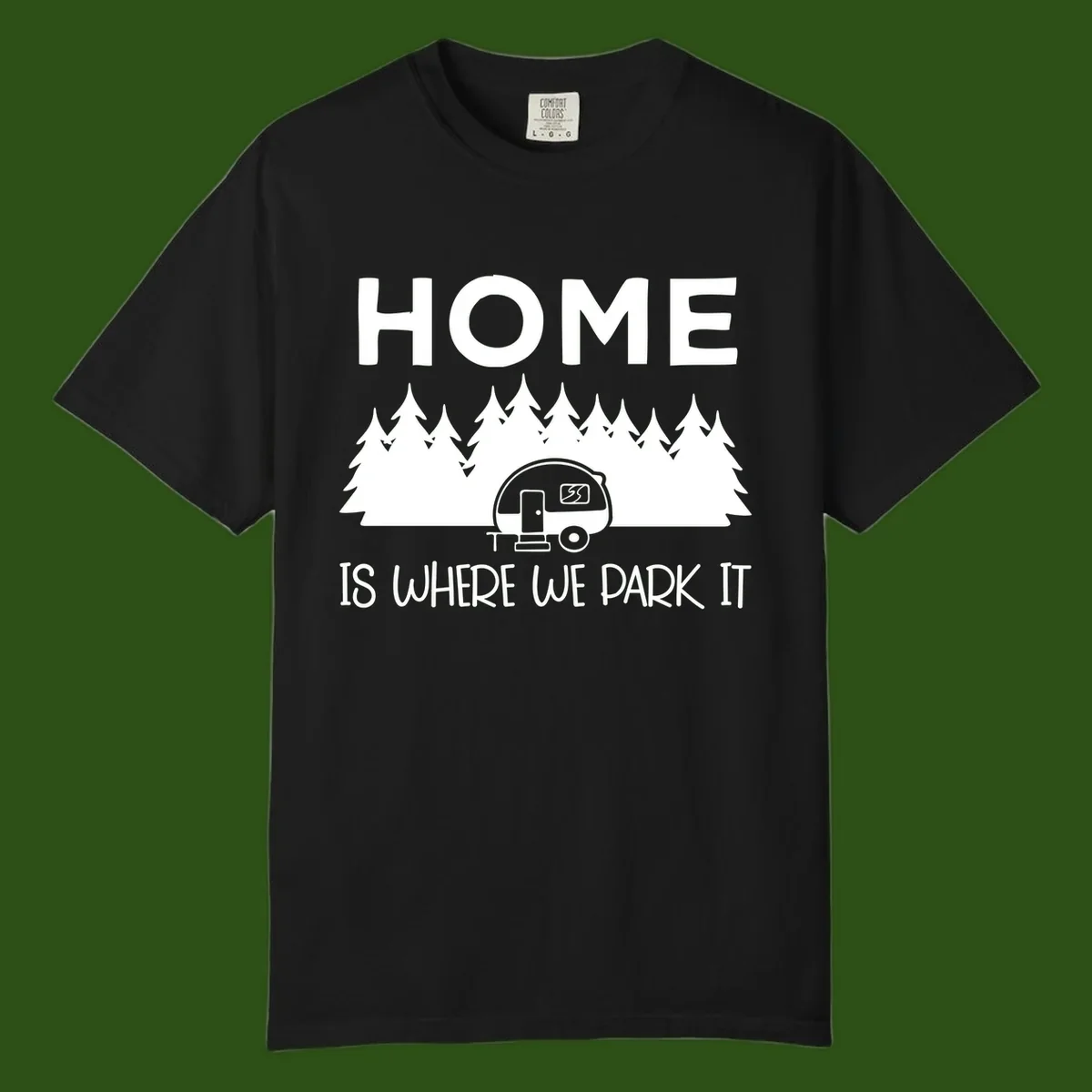 Home is where we park it design with travel trailer and forest trees on gray background