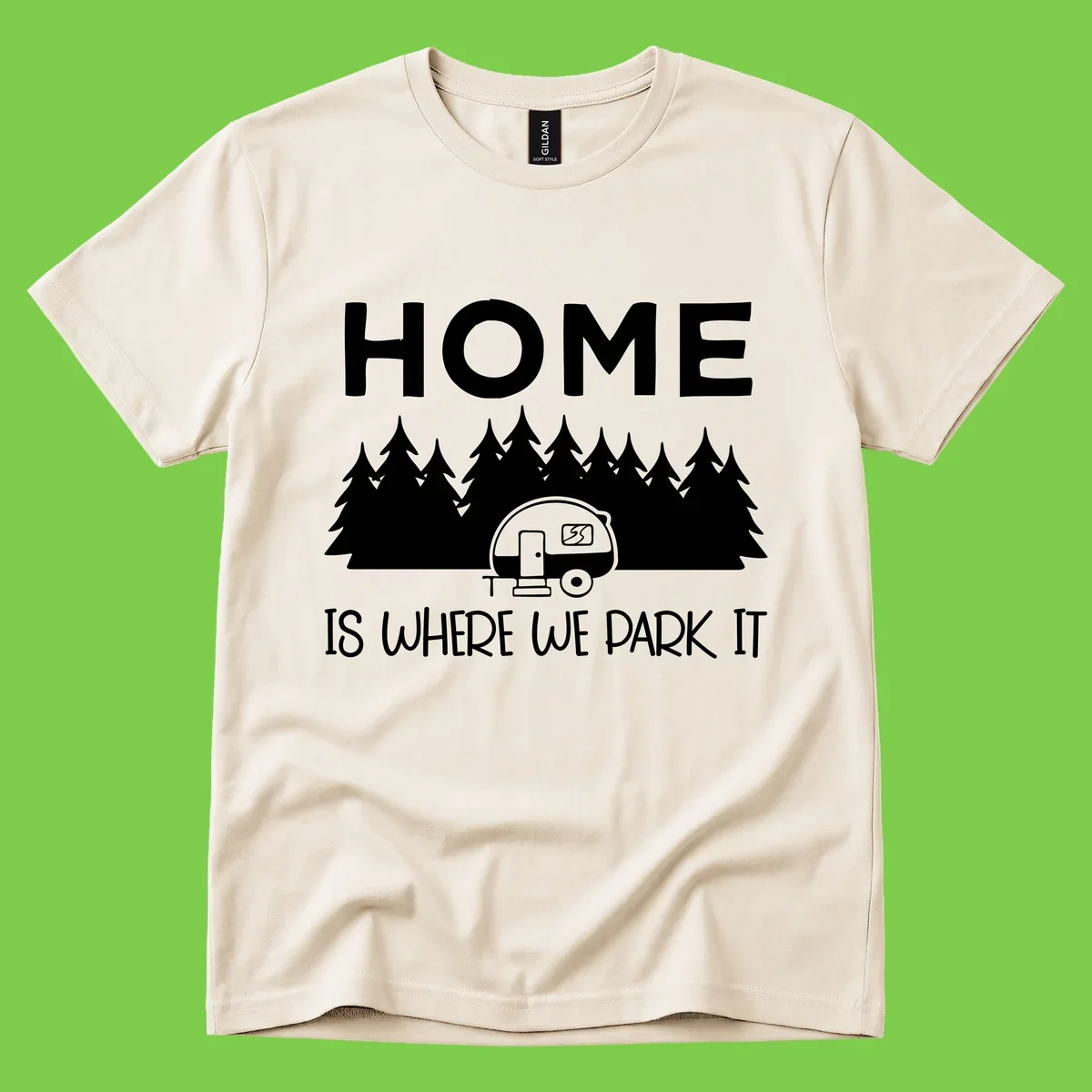 Home is where we park it design with travel trailer and forest trees on gray background