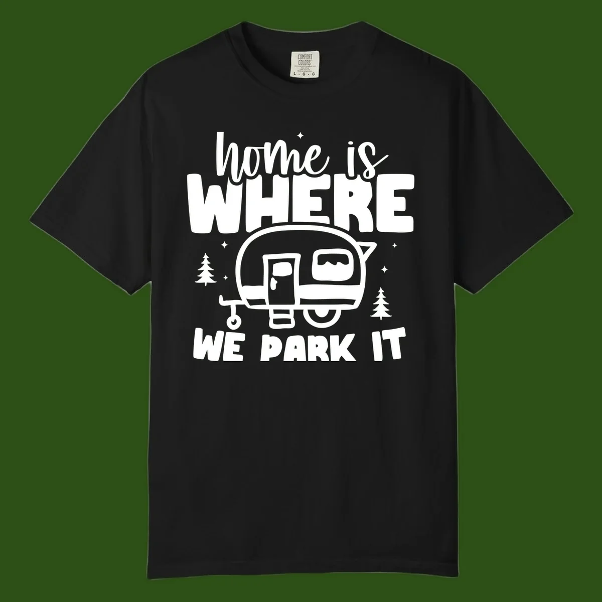 Retro-style design with 'home is where we park it' text and vintage travel trailer illustration surrounded by pine trees and sparkles