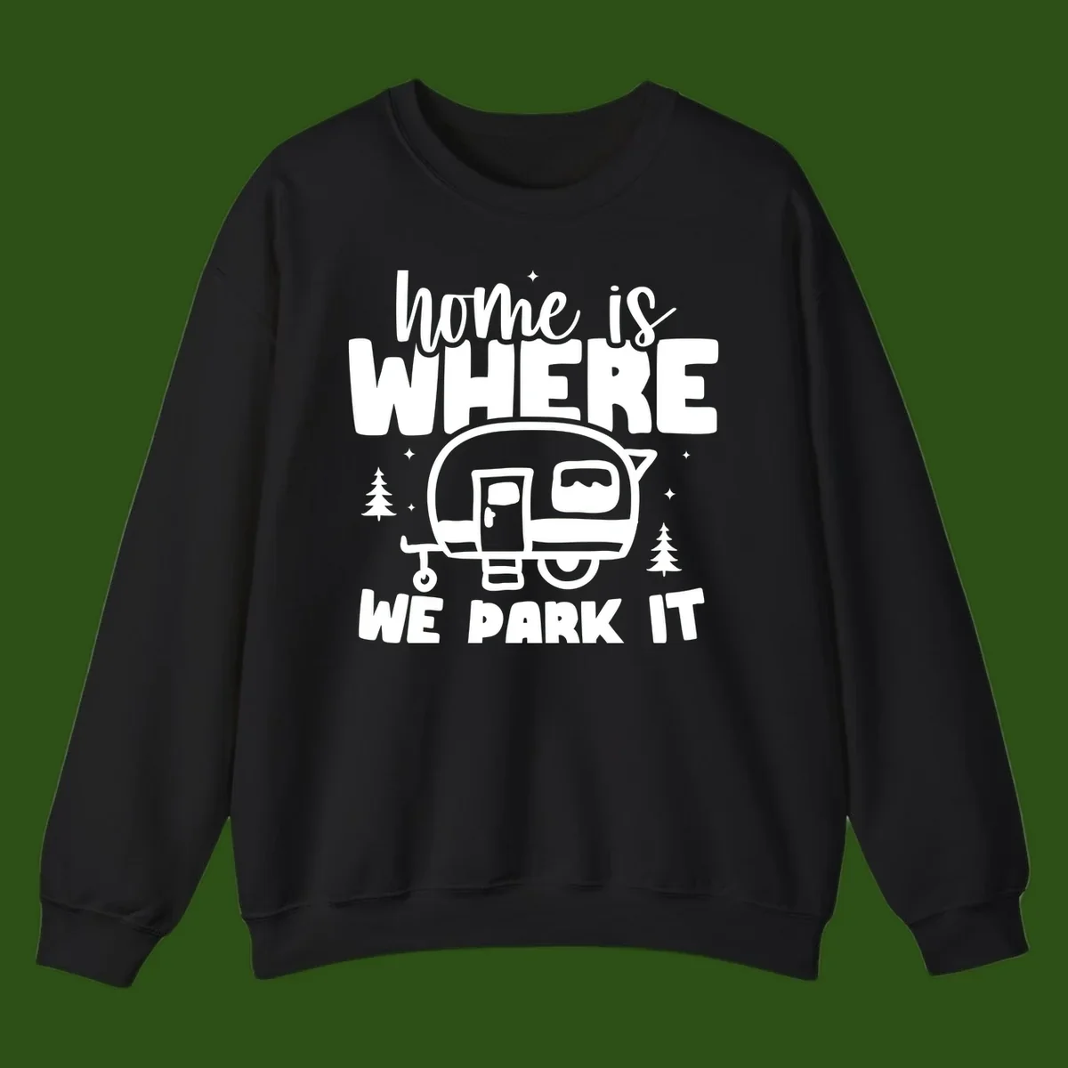 Retro-style design with 'home is where we park it' text and vintage travel trailer illustration surrounded by pine trees and sparkles
