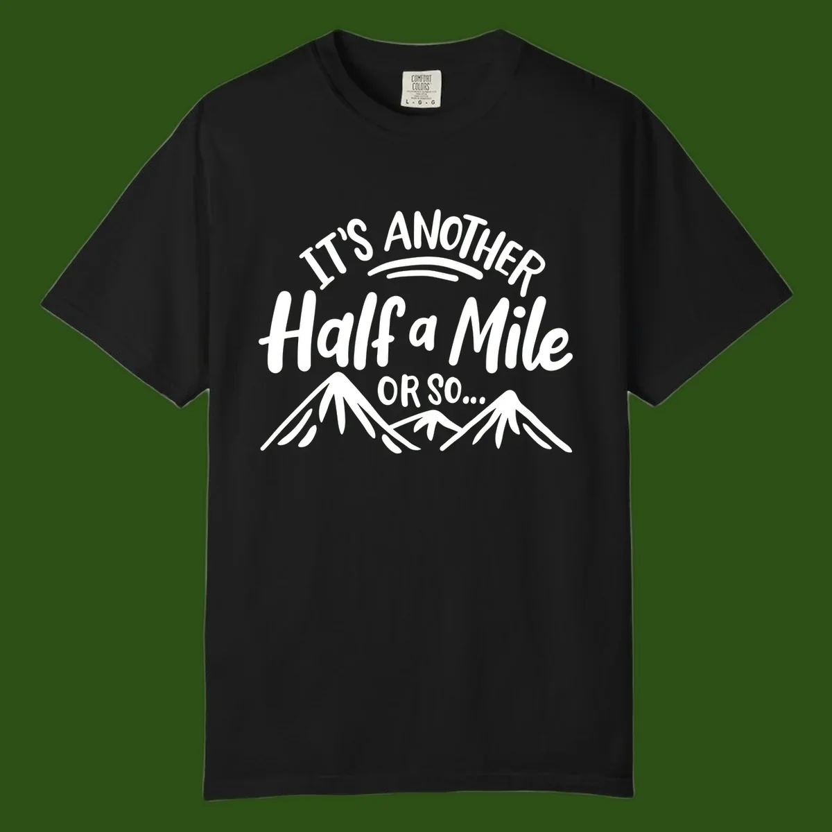 White text reading 'It's Another Half a Mile Or So...' with illustrated snow-capped mountains below on gray background