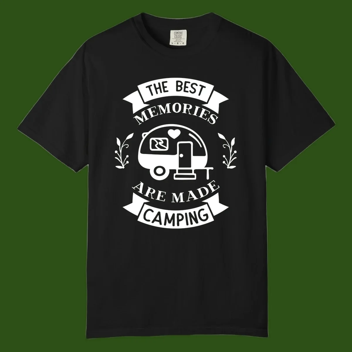 Vintage badge design with travel trailer and heart, text reading 'The Best Memories Are Made Camping' with decorative botanical branches