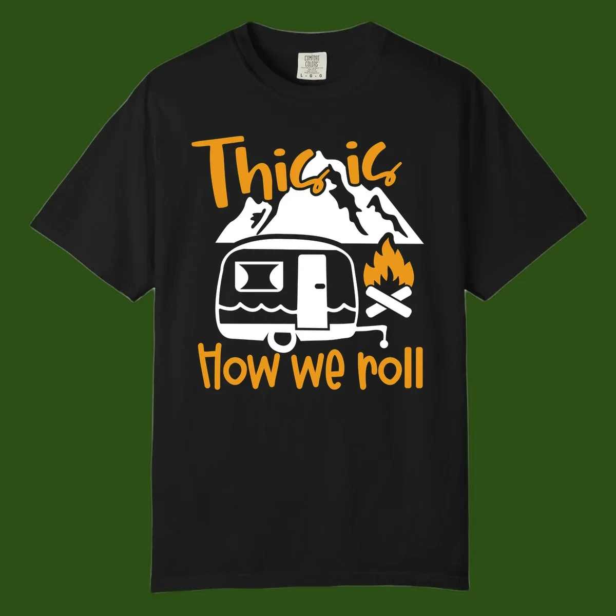 Vintage travel trailer with campfire and mountains, text reads 'This is how we roll' - camping lifestyle illustration